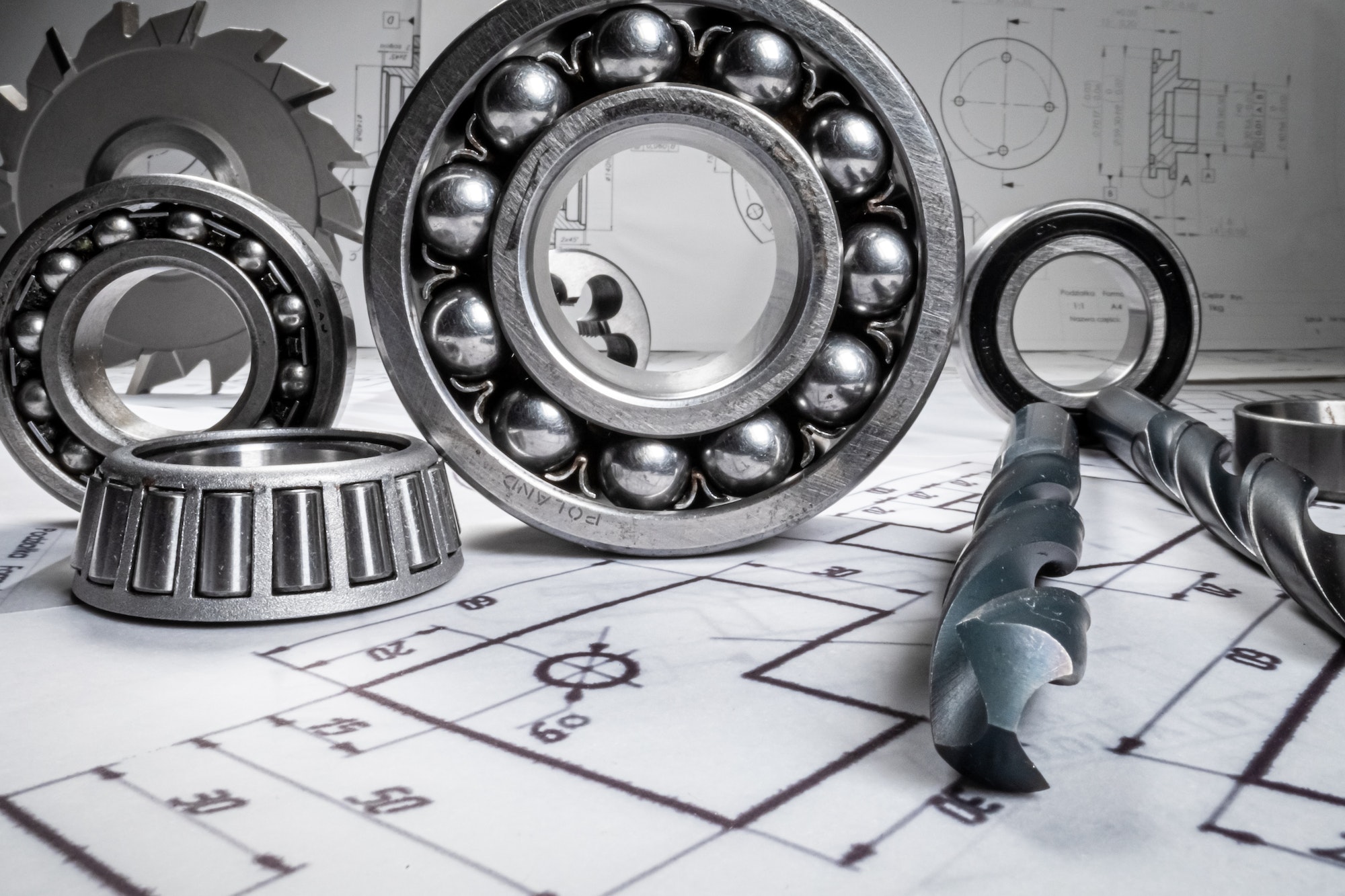 Mechanical diagrams, drill and bearings. Mechanical parts on designer desk.